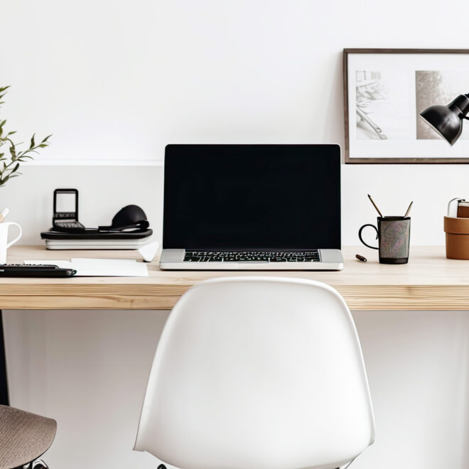 Office desk decorated with personal objects - plants, mugs, lamp, laptop