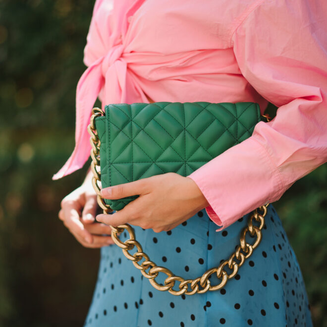 Woman holding faux leather clutch bag